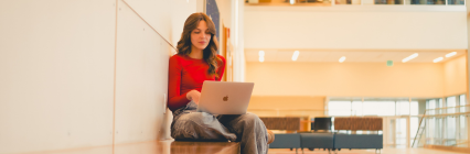 girl smiling at laptop sitting down