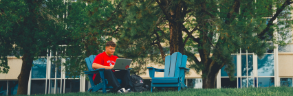 student looking at laptop outside