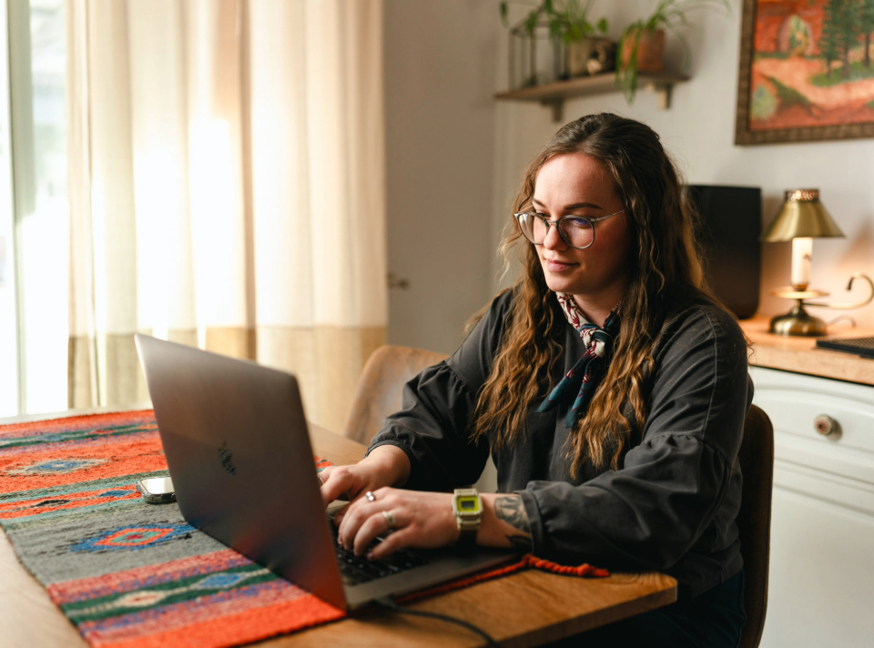 CSU Pueblo student working on her laptop in her kitchen.