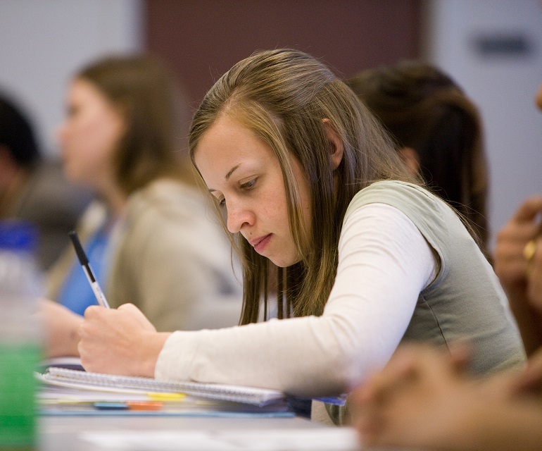 Student in classroom taking notes