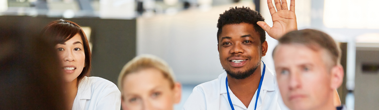 Nursing students attending older person in hospital bed