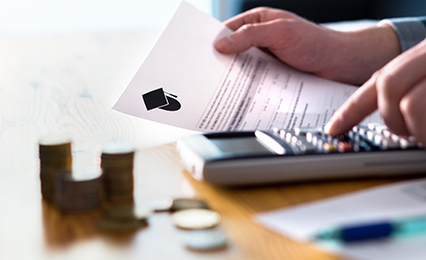 Two students in a building working on their computers