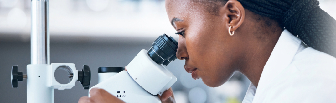 person looking through microscope
