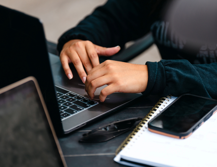 student typing on laptop